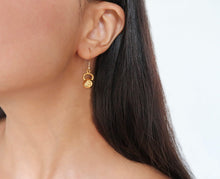 Athletic woman wearing 14kg gold kettlebell earrings received as a gift for her birthday.